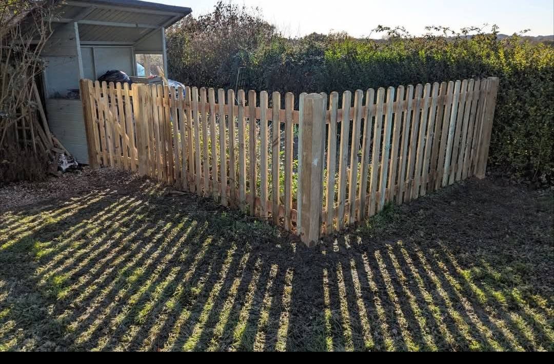 New picket fence around a kitchen garden corner in low sunlight